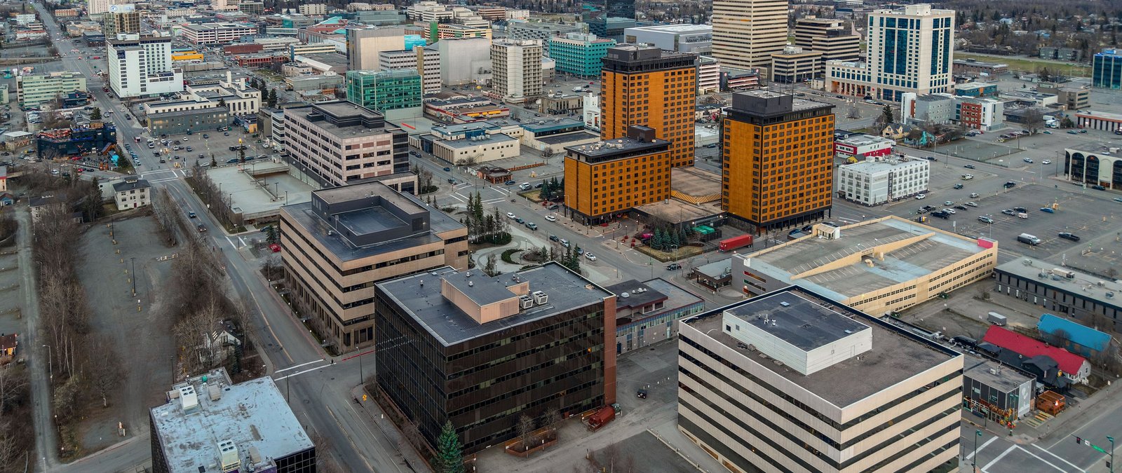 Aerial view of downtown Anchorage, Alaska, with office towers, streets and parking lots in autumn.