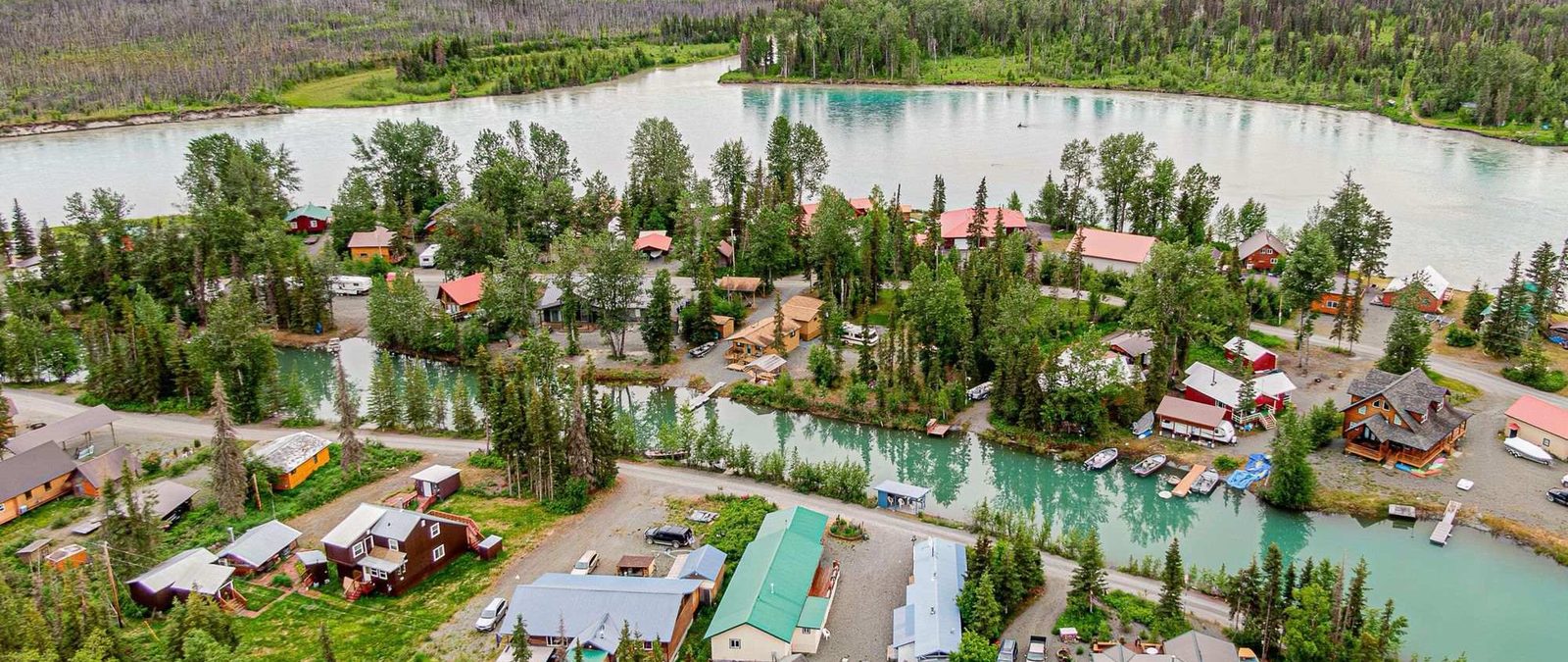 Aerial view of Sterling, Alaska, with homes, gravel roads and boat canals along the Kenai River.